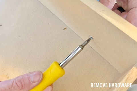 Removing furniture hardware from a dresser before painting with chalk paint.